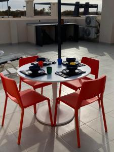 una mesa y cuatro sillas con tazones y platos en ella en Torre de la Horadada Apartment near beach, en Pilar de la Horadada