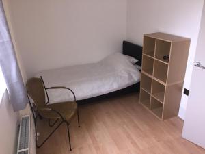 a small bedroom with a bed and a chair at Large 2-Bed House Derbyshire off Chatsworth rd in Chesterfield