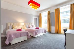 a bedroom with two beds with pink blankets at Stunning 2-Bed Apartment in Central Edinburgh in Edinburgh