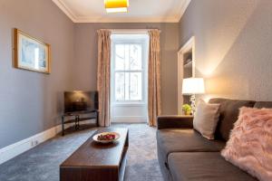 a living room with a couch and a tv at Stunning 2-Bed Apartment in Central Edinburgh in Edinburgh