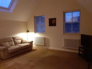 a living room with a couch and two windows at Modern 2nd floor 1 bed apartment in the heart of in Llandudno
