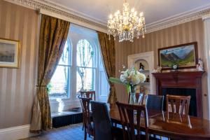 a dining room with a table and chairs and a chandelier at Newton Manor House - Luxury Retreat Sleeps 13 in Fife