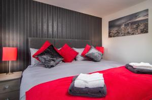 a bedroom with a large bed with red and black pillows at New Luxury Seaview Apt2 Free Parking Special Deal in Blackpool