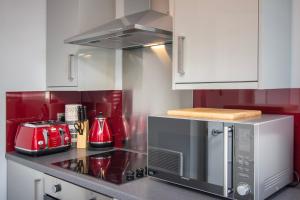 a kitchen with a stove and a microwave at New Luxury Seaview Apt2 Free Parking Special Deal in Blackpool