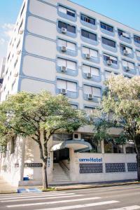 un edificio de hotel con escaleras y árboles delante en Hotel Letto Caxias, en Caxias do Sul