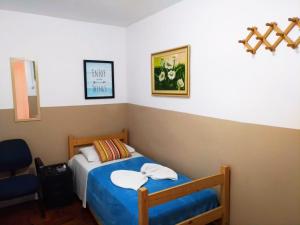 a small bedroom with a bed and a chair at Pousada Soft Brooklin in Sao Paulo