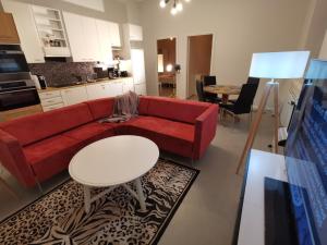- un salon avec un canapé rouge et une table dans l'établissement Kotkan Residenssi Apartments, à Kotka