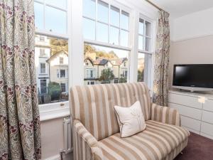 Una sala de estar con una silla y una ventana grande. en Livingstone House, en Llandudno