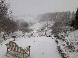 ławka w parku pokryta śniegiem na wzgórzu w obiekcie The Liscawn w mieście Torpoint