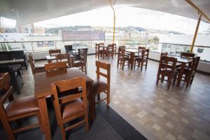 a restaurant with wooden tables and chairs and a balcony at Hotel Aristo Gold in Tunja