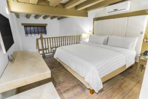 1 dormitorio con 1 cama grande y suelo de madera en GHL Hotel Armería Real, en Cartagena de Indias
