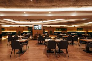 a dining room with tables and chairs and a television at Black Diamond Hotel in Tirana