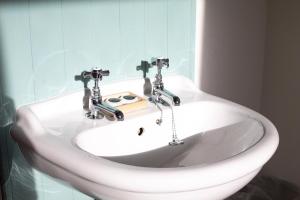 - un lavabo blanc avec deux robinets dans la salle de bains dans l'établissement Lavender House Weymouth, à Weymouth 71 autres photos