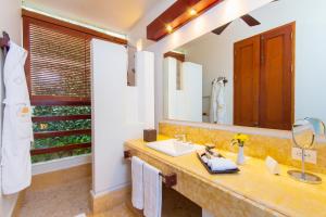 
a bathroom with a sink, mirror, and bathtub at Hotel Quadrifolio in Cartagena de Indias
