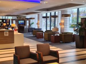 a lobby of a hotel with chairs and tables at Holiday Inn Express London - ExCel, an IHG Hotel in London
