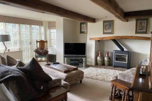 a living room with a couch and a tv at Luxury Country Cottage in Smeeth