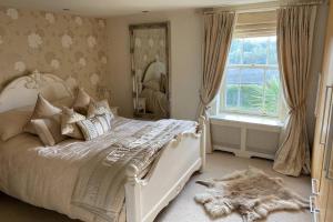 a bedroom with a white bed and a window at Luxury Country Cottage in Smeeth