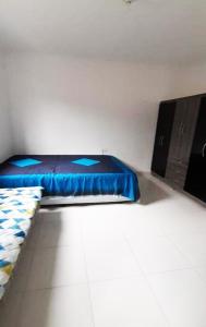 a room with a bed with a blue sheet on it at Residencial Alemão in Guarujá