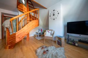 a living room with a staircase and a flat screen tv at Apartamenty Tatrzańskie Turnie in Zakopane