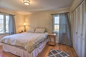 ein Schlafzimmer mit einem Bett und zwei Fenstern in der Unterkunft Cozy Appleton Getaway with Screened-In Porch and Yard! in Appleton