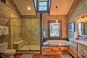 a bathroom with a tub and a shower and a toilet at Luxurious Mountain Getaway with Game Room and Hot Tub! in Mineral Bluff +36 photos