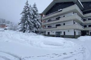 pokryty śniegiem dziedziniec przed budynkiem w obiekcie Il rifugio dello sciatore a 200 m dagli impianti. w mieście Aprica