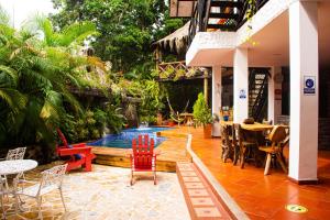 a patio with chairs and a swimming pool at Hostal Antawara Tayrona in El Zaino