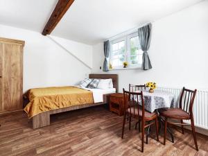 1 dormitorio con 1 cama, mesa y sillas en Pension Slunečnice, en Pec pod Sněžkou