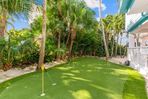 a golf course with two putting greens and palm trees at Aquarius North in Stuart