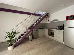 a kitchen with a purple staircase in a room at Le Soulier En Cévennes 4 étoiles in Saint-Martin-de-Valgalgues