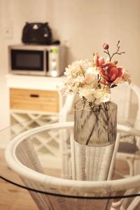 a vase of flowers sitting on a glass table at Monteurwohnung Oyten bei Bremen A1 dat Landhuus in Oyten