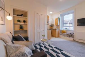 ein Wohnzimmer mit einem Sofa und einem Tisch in der Unterkunft Stylish and Comfortable City Centre Apartment in Edinburgh