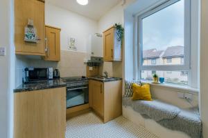 eine kleine Küche mit einem Waschbecken und einem Fenster in der Unterkunft Stylish and Comfortable City Centre Apartment in Edinburgh
