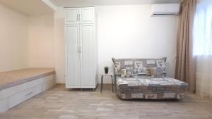 a bedroom with a bed and a chair in a room at Apartaments at Pan Kalinovsky in Pyatigorsk