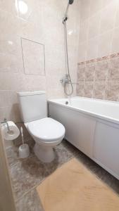 a bathroom with a toilet and a tub and a sink at Apartaments at Pan Kalinovsky in Pyatigorsk