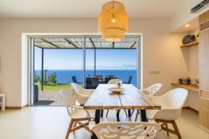 a dining room with a table and chairs with a view at Villa Flora - Nature & Tranquility - Heated pool optional in Jardim do Mar
