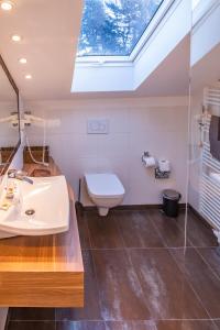 a bathroom with a sink and a toilet with a skylight at Seaside-Townhouse in Timmendorfer Strand