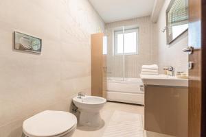 a white bathroom with a toilet and a sink at Apartament 2 camere Narcis in Braşov +17 photos