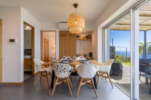 a kitchen and dining room with a table and chairs at Cantinho da Natureza - Nature & Tranquility - Heated pool optional in Jardim do Mar