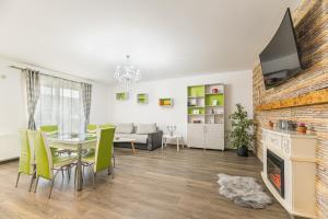 een woonkamer met een eettafel en een tv bij Apartament 2 camere Narcis in Braşov
