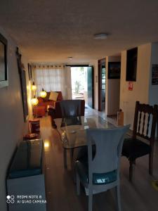 ein Wohnzimmer mit einem Tisch, Stühlen und einem Sofa in der Unterkunft Hostal Villa Rosita in Villa de Leyva