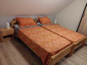 2 Einzelbetten in einem Schlafzimmer mit einem Nachttisch in der Unterkunft Gite "le piémont des Vosges " in Stotzheim