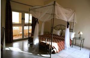 a bedroom with a bed with a canopy at Villa Rosa in Dakar