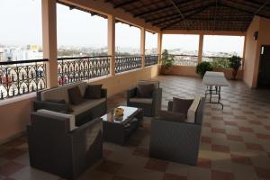 un balcón con sofás y un perro sentado en una mesa en Villa Rosa, en Dakar