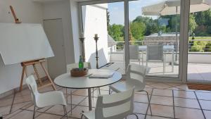 a room with a table and chairs and a balcony at Somnar Panoramaloft mit Hästens Betten - Rheinblick 150qm in Neuss