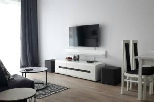 Lux Apartment close to Medicover and Paley في وارسو: غرفة معيشة مع تلفزيون بشاشة مسطحة على جدار