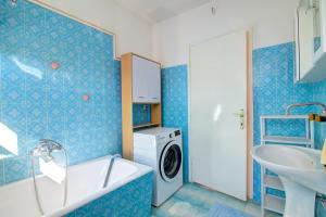 a blue bathroom with a washing machine and a sink at Apartments Diego in Sveti Juraj