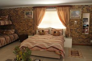 a bedroom with two teddy bears on a bed at Quest Bed And Breakfast in Melkbosstrand