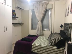 1 dormitorio con cama y ventana en Apto. frente ao mar no Gonzaga - melhor localização! en Santos