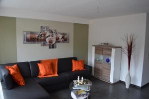 a living room with a blue couch and orange pillows at Apartment mit Meeresblick in Binz